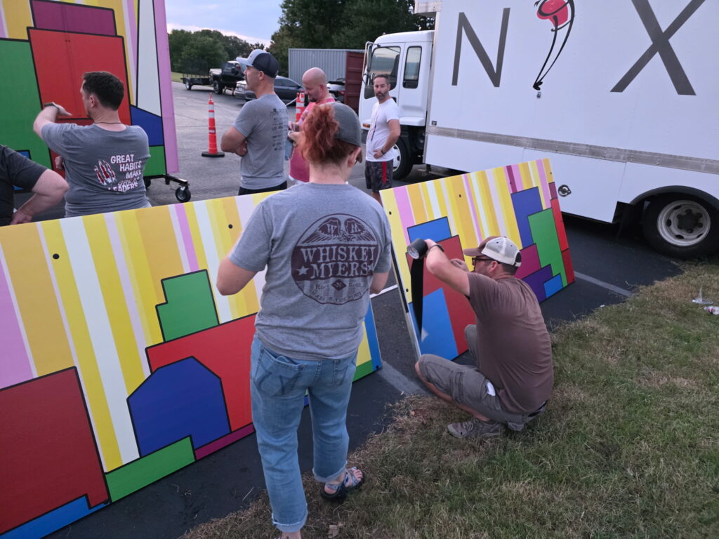 Prop crew volunteers painting and assembling show set pieces