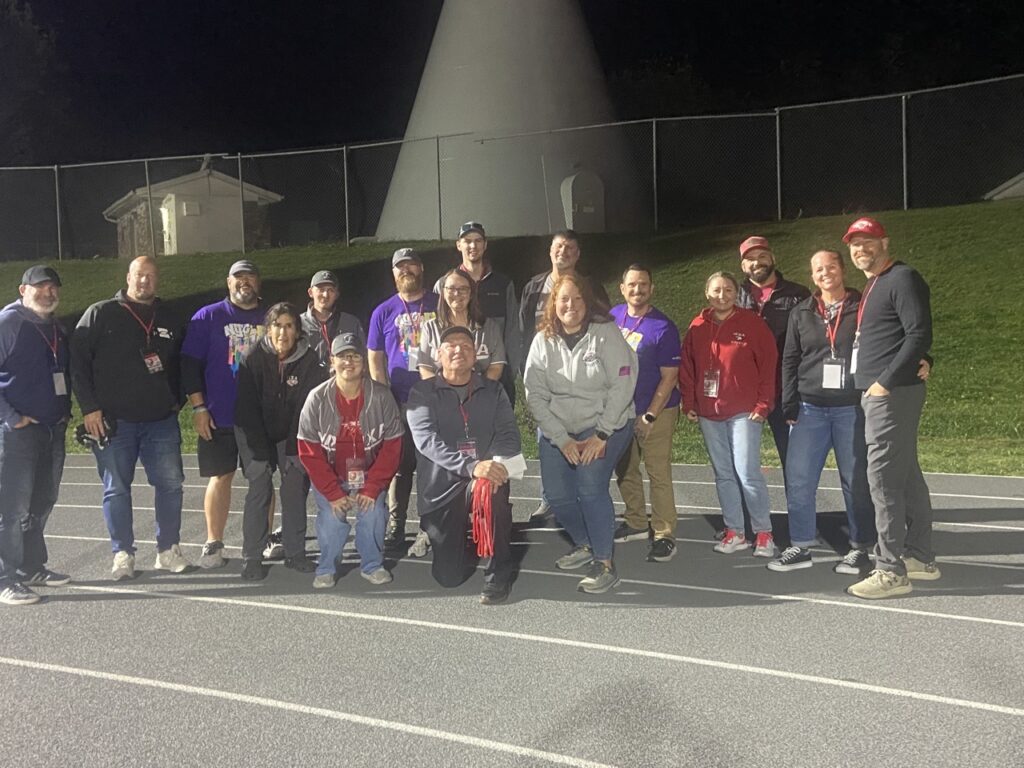 Volunteers gathered on the practice field at night
