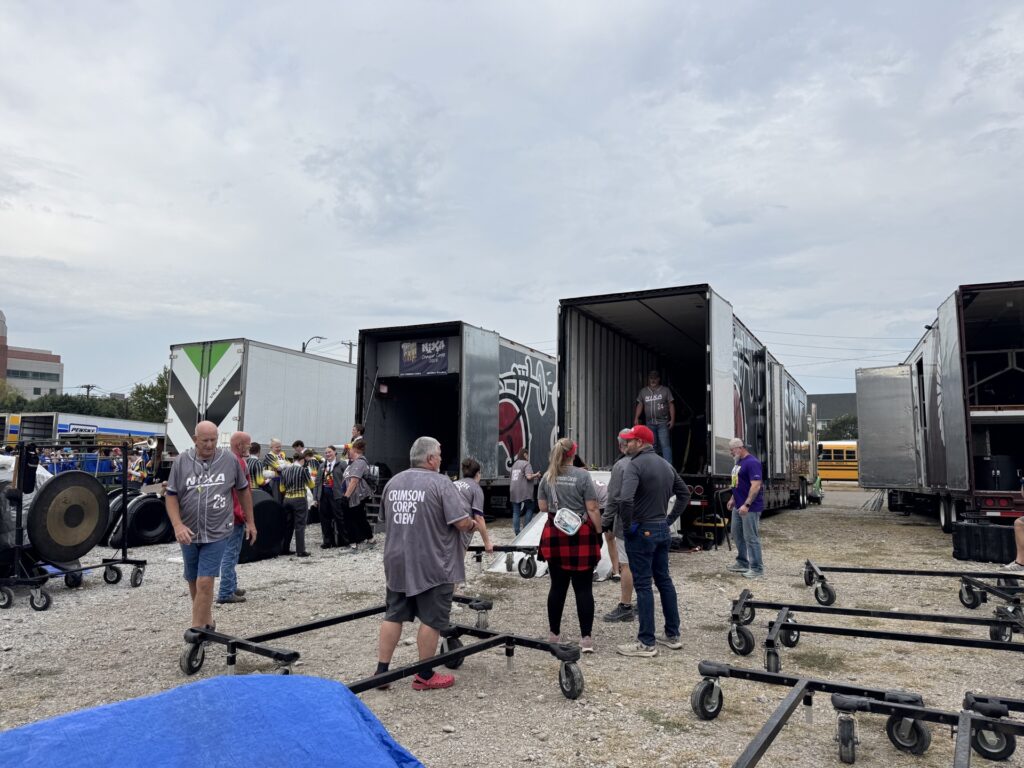 Crimson Corps Crew volunteers unloading equipment trailers before a show